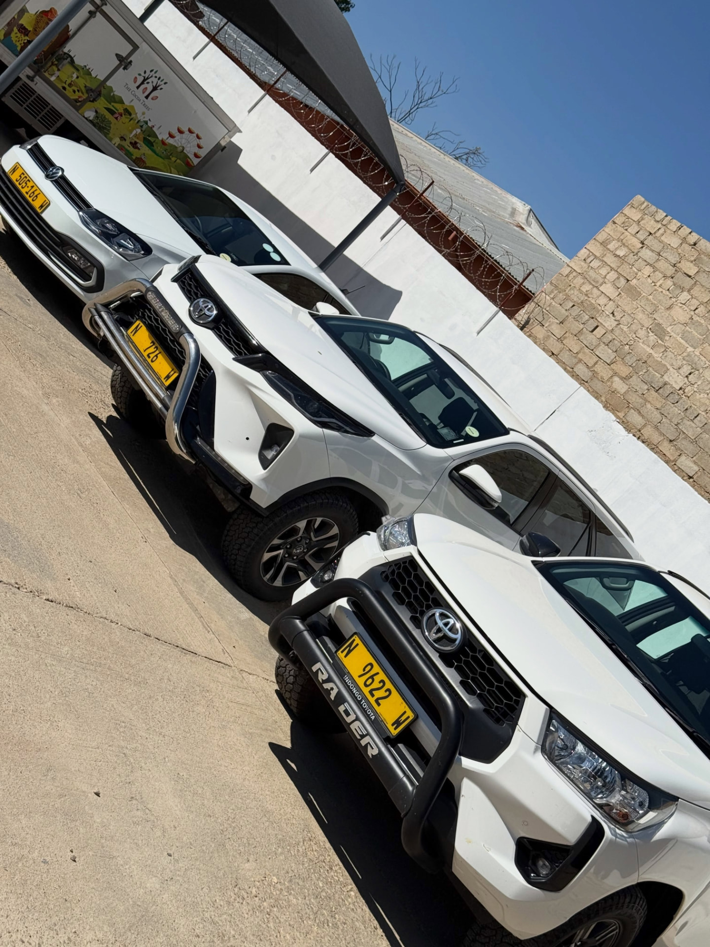 White Toyota bakkies and SUVs parked in the New Trend Car Rental yard